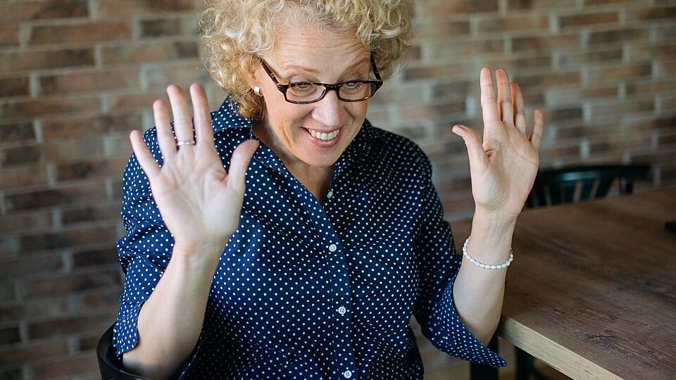 Donna sorridente che partecipa a una seduta di terapia psicologica online da casa con il suo laptop