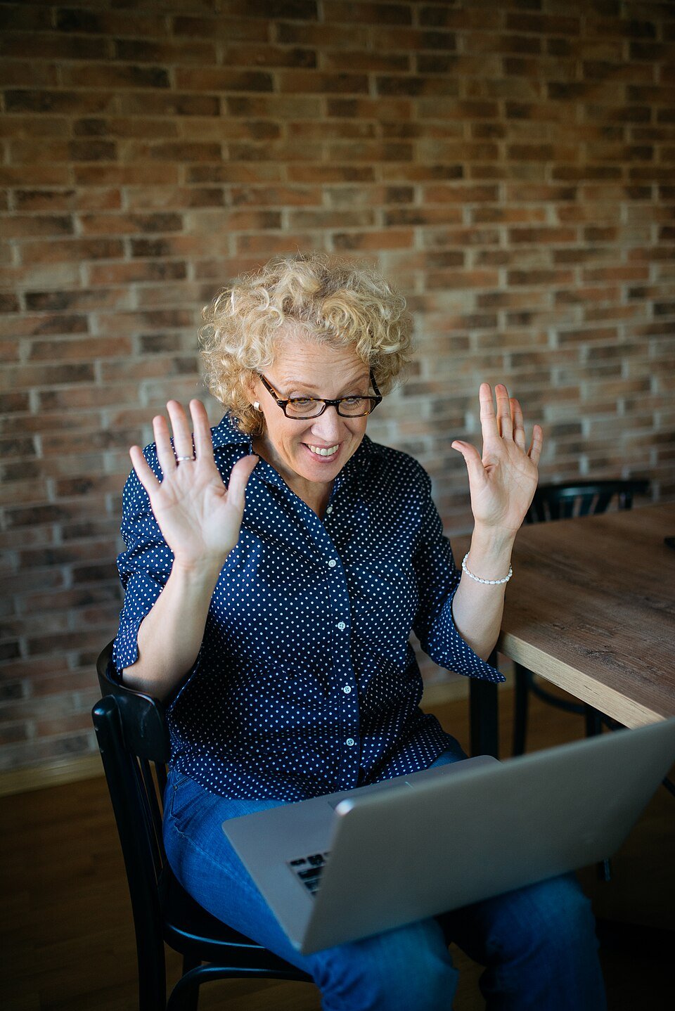 Donna sorridente che partecipa a una seduta di terapia psicologica online da casa con il suo laptop